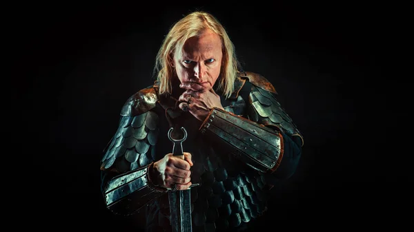 Мощный рыцарь-блондин с мечом на темном фоне — стоковое фото