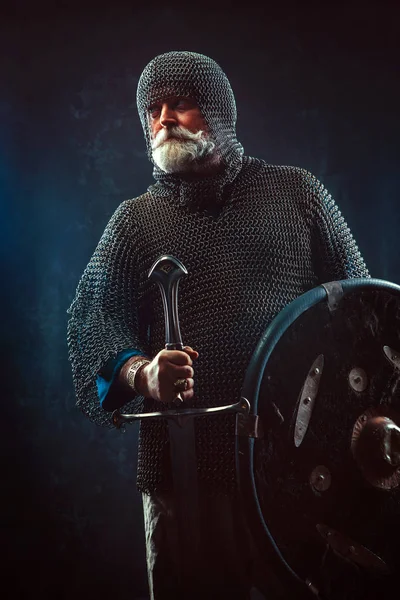 Koyu arka plan üzerinde kılıçla güçlü sakallı knight — Stok fotoğraf