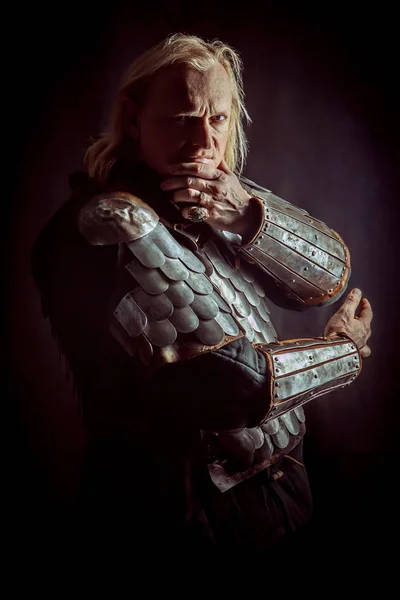 Powerful blond knight is standing with the crossed arms on the dark background — Stock Photo, Image