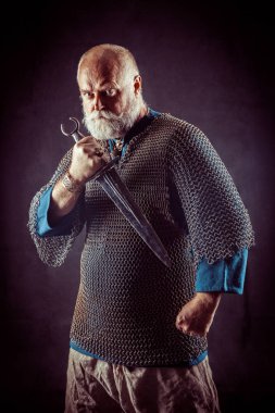 Koyu arka plan üzerinde kılıçla güçlü sakallı knight