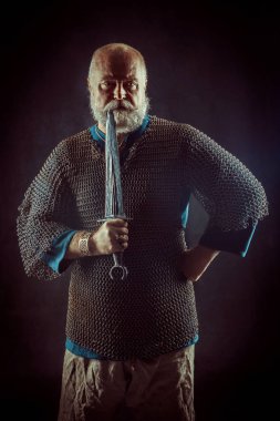 Koyu arka plan üzerinde kılıçla güçlü sakallı knight