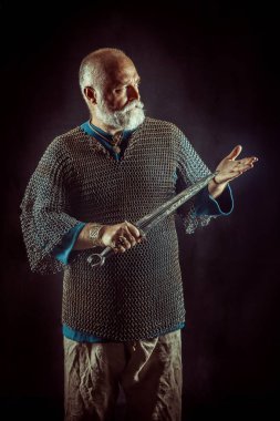 Koyu arka plan üzerinde kılıçla güçlü sakallı knight