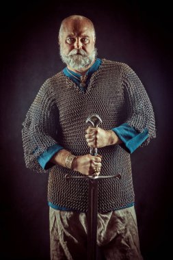 Koyu arka plan üzerinde kılıçla güçlü sakallı knight
