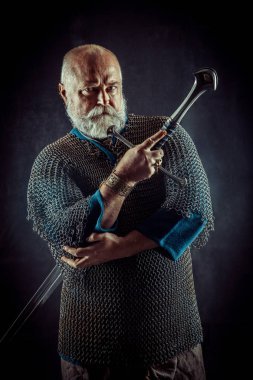 Koyu arka plan üzerinde kılıçla güçlü sakallı knight