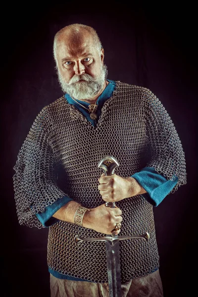 Powerful bearded knight with the sword on the dark background — Stock Photo, Image