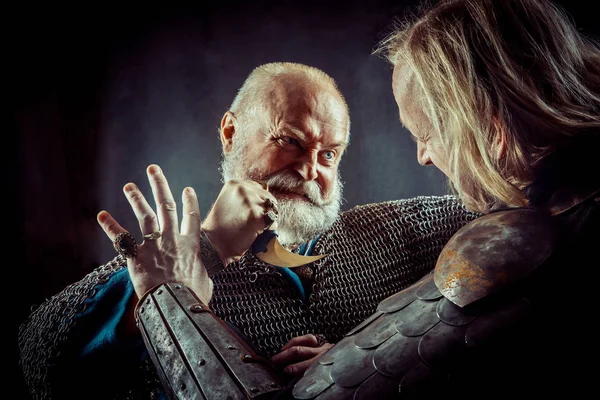 Dagger fight between two medieval knights on the dark background