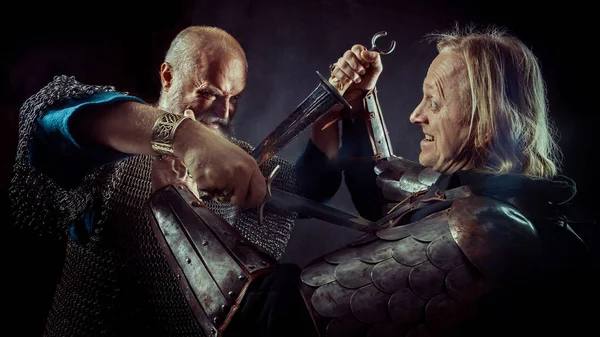 Hançer mücadele arasında koyu arka plan üzerinde iki ortaçağ Şövalyeleri — Stok fotoğraf