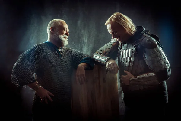 Two powerful knights resting in the tavern. Dark background. — Stock Photo, Image