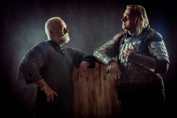 Two powerful knights resting in the tavern. Dark background. — Stock Photo, Image
