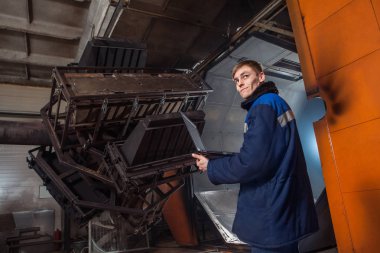Şişirme plastik büyük fabrika fırında. İşçi laptop ile kalıplama işlemi denetleme.