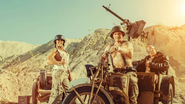 Patrulla militar de dos poderosos soldados calvos y una mujer en el fondo del desierto . — Foto de Stock