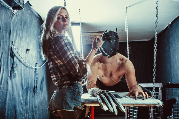 Young couple in a role playing game, girl is holding a man in the dog mask on the chain. — Stock Photo, Image