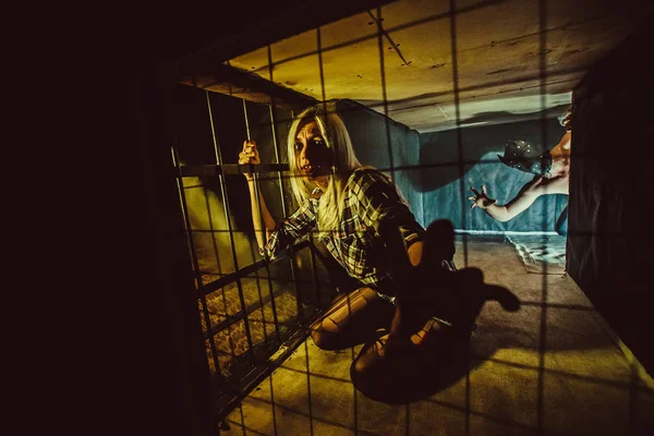 Frightened blond woman in the dark cage. — Stock Photo, Image