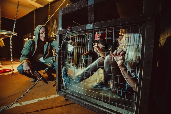 Maldito maníaco y su víctima femenina en la jaula . —  Fotos de Stock