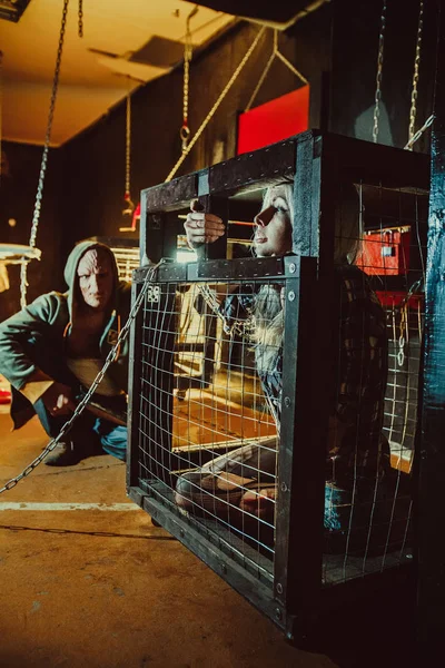 Maldito maníaco y su víctima femenina en la jaula . — Foto de Stock