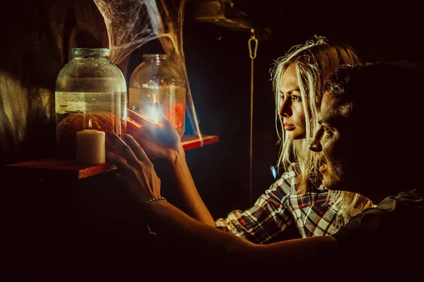 Verängstigtes Paar blickt auf die eingemachten Gliedmaßen in der Höhle des Wahnsinnigen. — Stockfoto