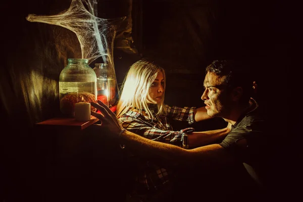 Frightened couple is looking at the canned limbs in the maniac's lair. — Stock Photo, Image