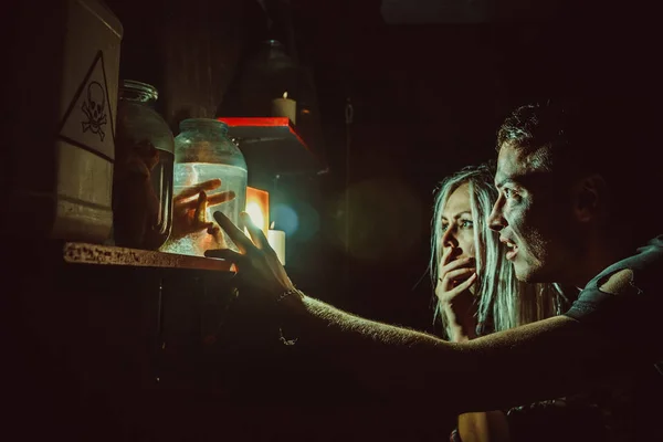 Pareja asustada está mirando las extremidades enlatadas en la guarida del maníaco . —  Fotos de Stock