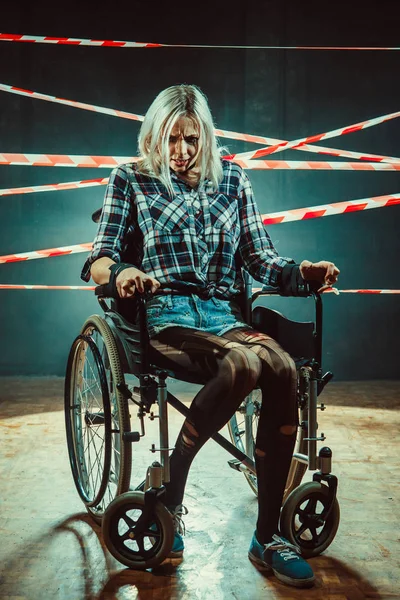 Красивая женщина в инвалидной коляске на темном фоне . — стоковое фото