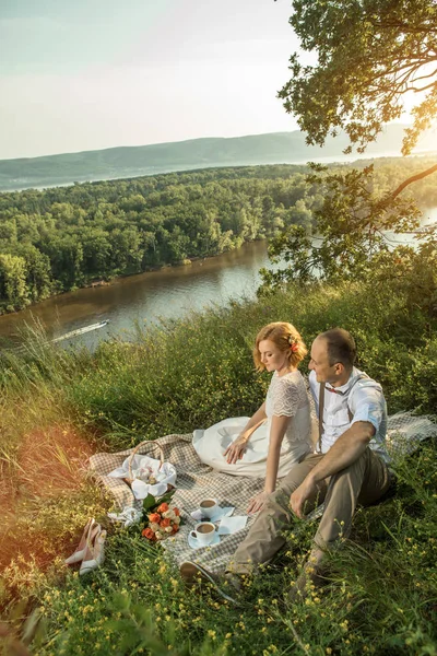 Attraktives Paar genießt romantisches Picknick bei Sonnenuntergang auf dem Land — Stockfoto