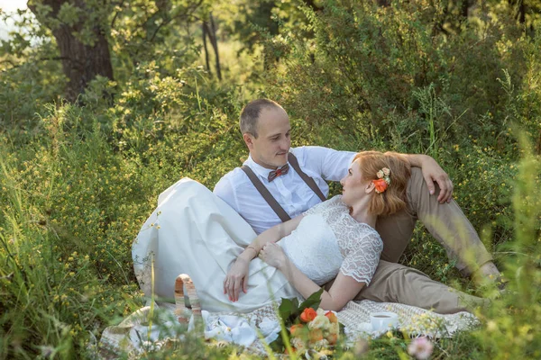 Привлекательная пара наслаждается романтическим закатом пикник в сельской местности — стоковое фото