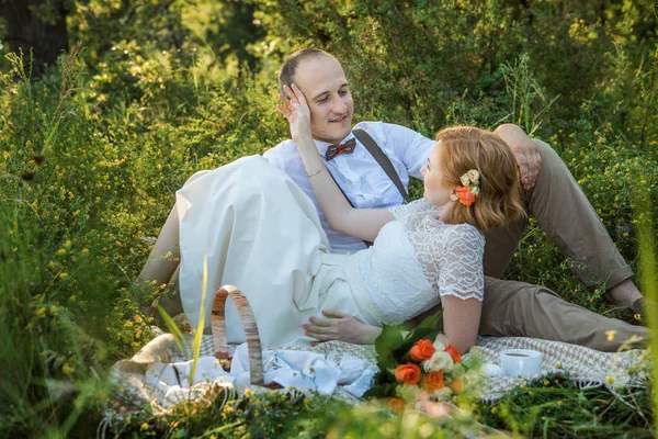 Atractiva pareja disfrutando de un romántico picnic al atardecer en el campo —  Fotos de Stock