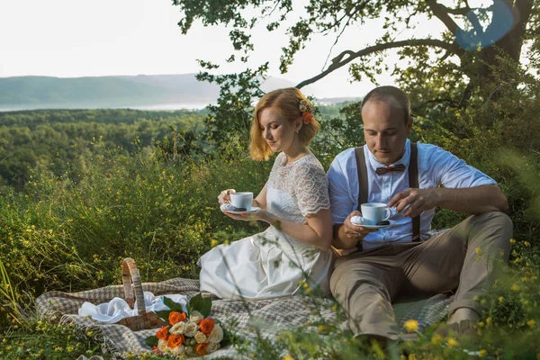 田舎でロマンチックな夕日のピクニックを楽しんでいる魅力的なカップル — ストック写真
