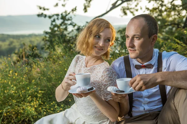 Atractiva pareja disfrutando de un romántico picnic al atardecer en el campo —  Fotos de Stock