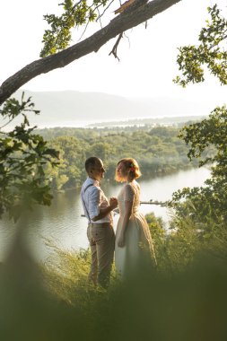 Tepenin üstünde romantik günbatımı zevk çekici çift.
