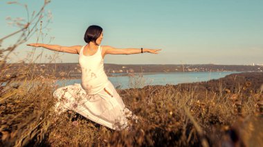 Doğa açık havada üzerinde doğum öncesi yoga yaparken güzel hamile kadın.
