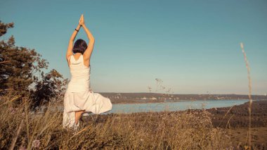 Doğa açık havada üzerinde doğum öncesi yoga yaparken güzel hamile kadın.