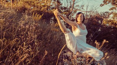 Doğa açık havada üzerinde doğum öncesi yoga yaparken güzel hamile kadın.