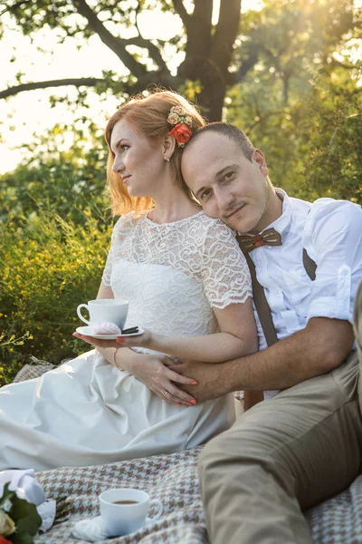 Casal atraente desfrutando de piquenique romântico ao pôr do sol no país — Fotografia de Stock