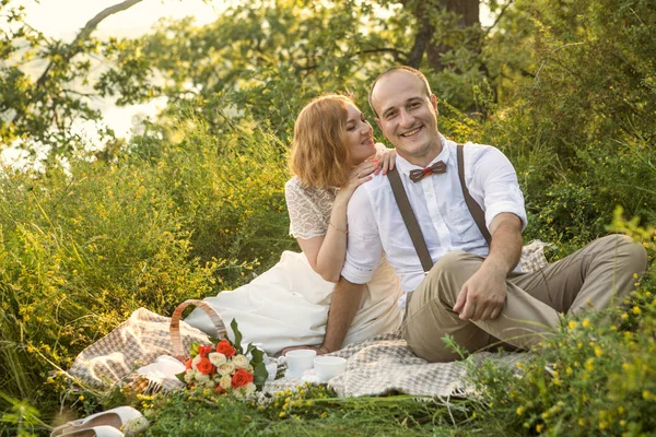 Atractiva pareja disfrutando de un romántico picnic al atardecer en el campo —  Fotos de Stock