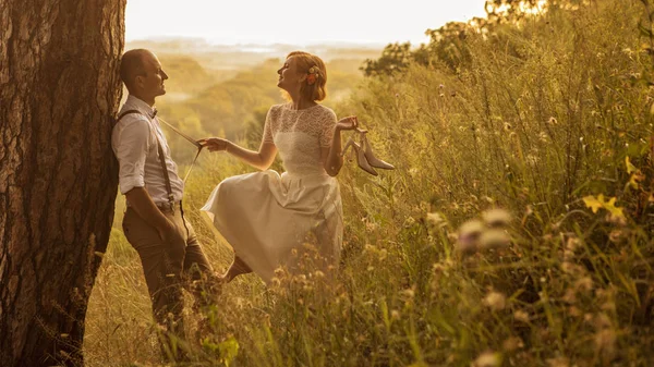 Casal atraente desfrutando de pôr do sol romântico no topo da colina . — Fotografia de Stock