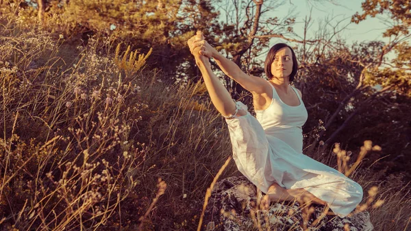 Doğa açık havada üzerinde doğum öncesi yoga yaparken güzel hamile kadın.