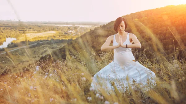 Doğa açık havada üzerinde doğum öncesi yoga yaparken güzel hamile kadın. — Stok fotoğraf