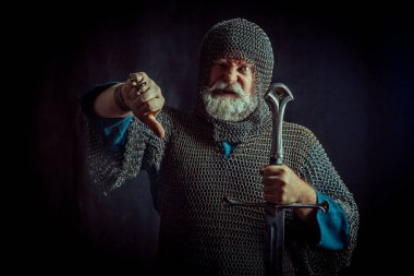Koyu arka plan üzerinde kılıçla güçlü sakallı knight