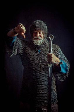Koyu arka plan üzerinde kılıçla güçlü sakallı knight