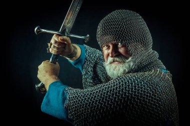 Koyu arka plan üzerinde kılıçla güçlü sakallı knight