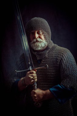 Koyu arka plan üzerinde kılıçla güçlü sakallı knight