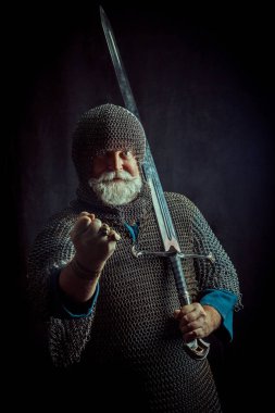 Koyu arka plan üzerinde kılıçla güçlü sakallı knight