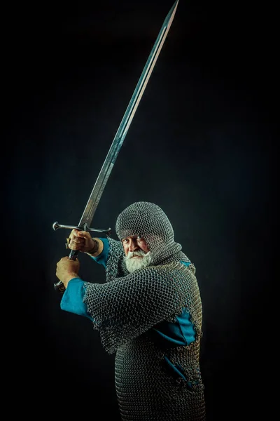Erős szakállas lovag karddal a sötét háttér — Stock Fotó