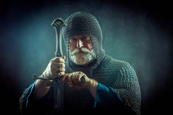 Powerful bearded knight with the sword on the dark background — Stock Photo, Image