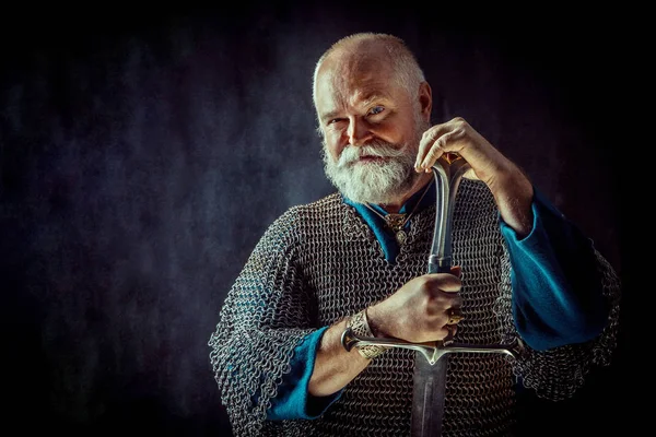 Powerful bearded knight with the sword on the dark background — Stock Photo, Image