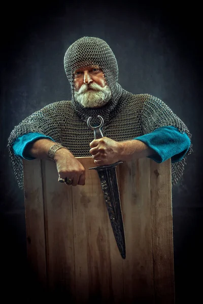 Koyu arka plan üzerinde hançeriyle güçlü sakallı knight — Stok fotoğraf