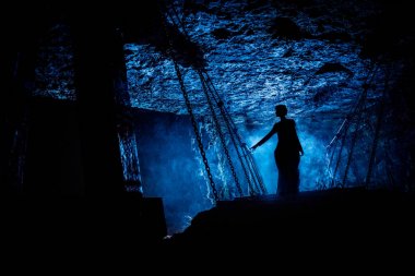 Asma köprü üzerinde gizemli bir cadı silueti ile onun etrafında duman bulutları.