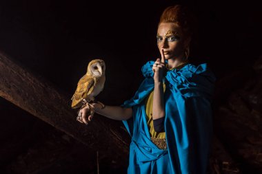 Güzel kırmızı saçlı cadı ile beyaz baykuş.