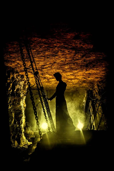 Siluet seorang penyihir misterius di jembatan gantung dengan awan asap di sekelilingnya . — Stok Foto