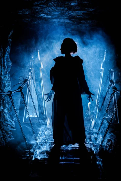 Silhouette of a mysterious witch on the suspension bridge with clouds of smoke around her. — Stock Photo, Image